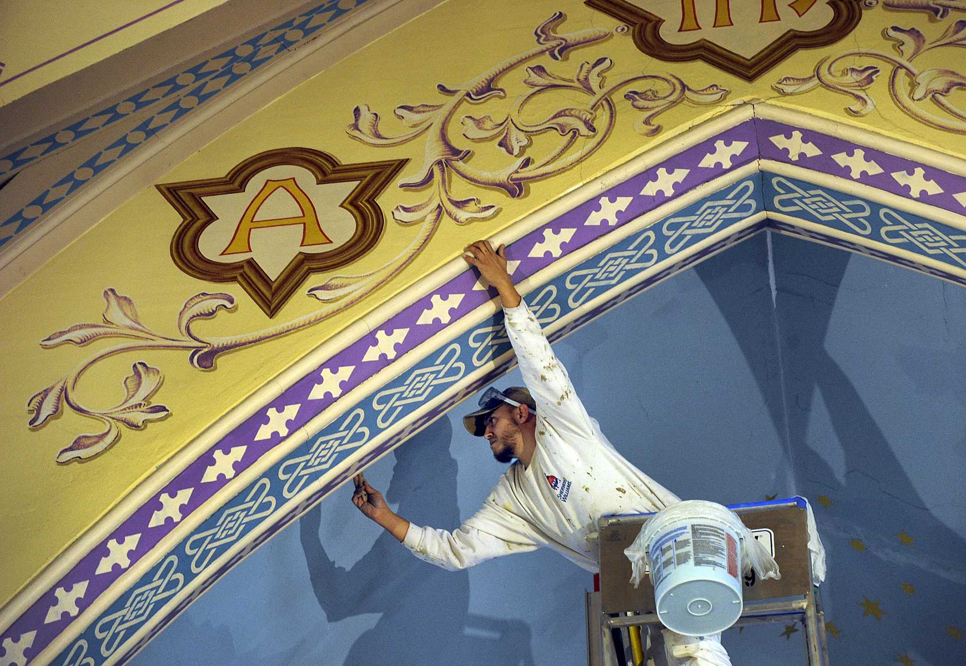 John Lora of Danbury works at repairing the plaster in the ceiling of Trinity Episcopal Church in Newtown.
